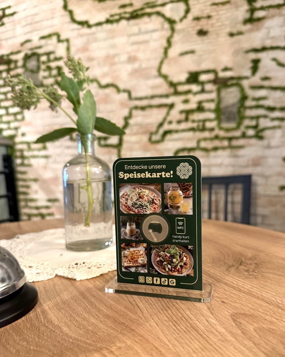 Der Aufsteller von Picknick Waffles and More auf einem Tisch im Café: „Entdecke unsere Speisekarte!“ mit Fotos der Gerichte und NFC